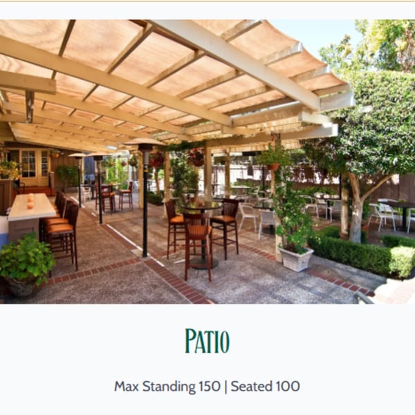 Outdoor patio at MacArthur Park Restaurant with shaded seating, high-top tables, and lush greenery.