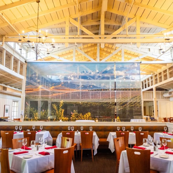 The MacArthur Park Restaurant dining room with set tables and a large scenic mural.