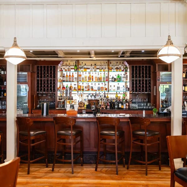 The MacArthur Park Restaurant and Bar features a well-stocked bar with numerous bottles and bar stools.